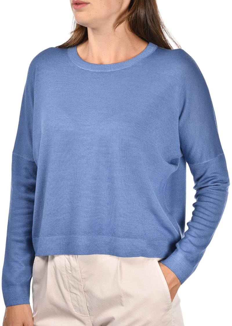 Woman wearing a blue sweater with beige pants on a white background