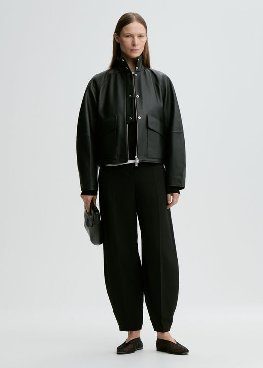 Person wearing a black outfit with a jacket and pants on a white background