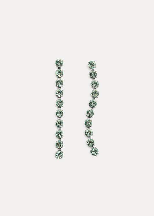 Pair of long, thin earrings with green gemstones on a light gray background