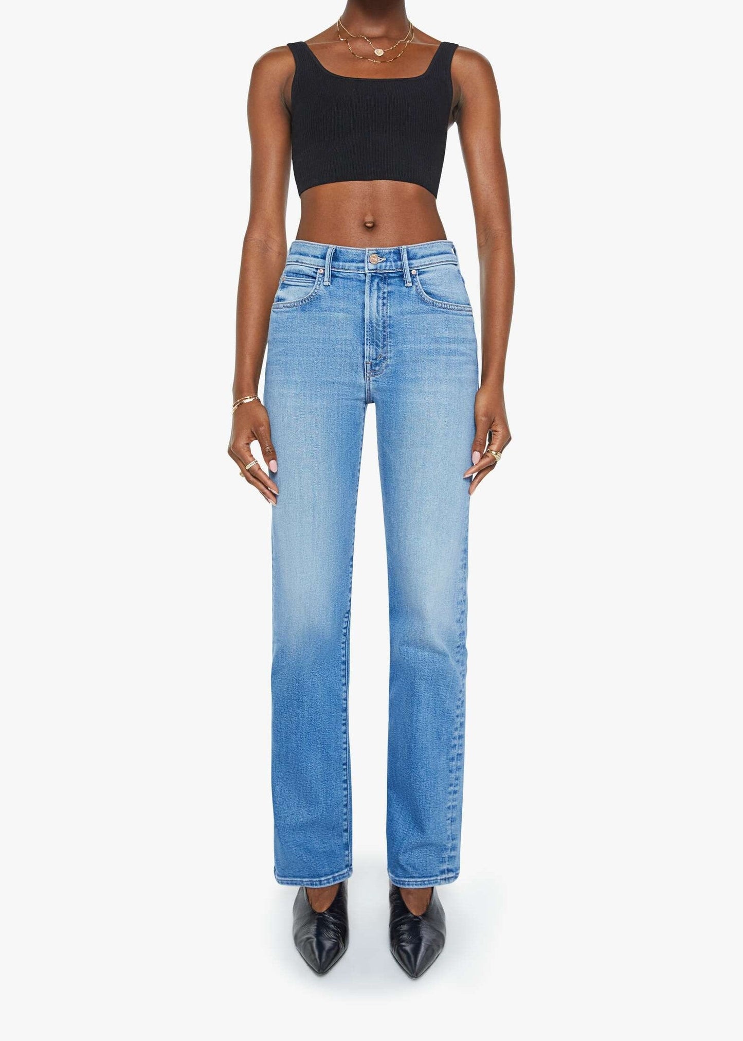 Person wearing blue jeans and a black top on a white background