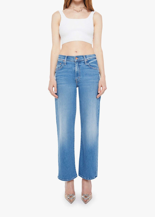 Woman wearing a white crop top and blue jeans on a white background