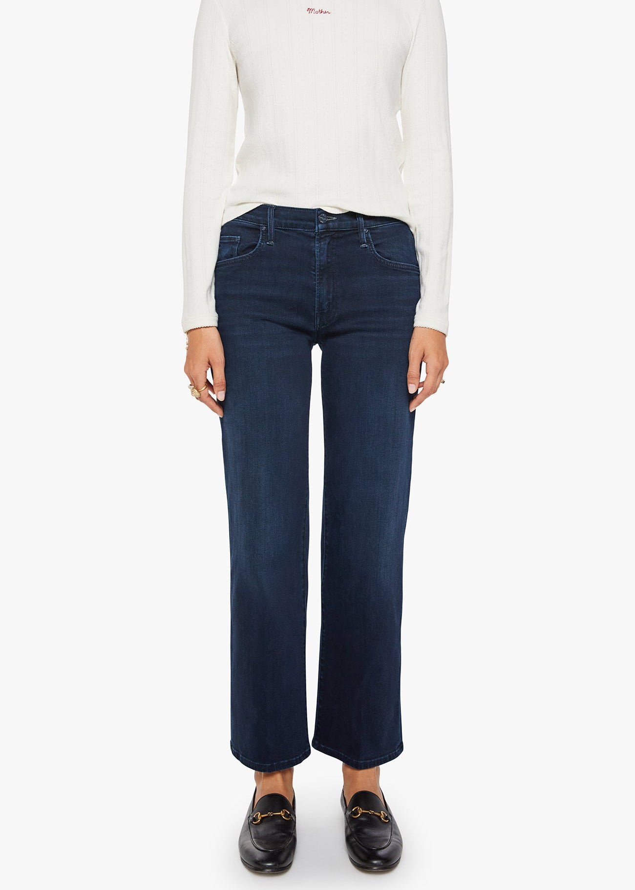 Person wearing a white long-sleeve shirt and dark blue jeans on a white background