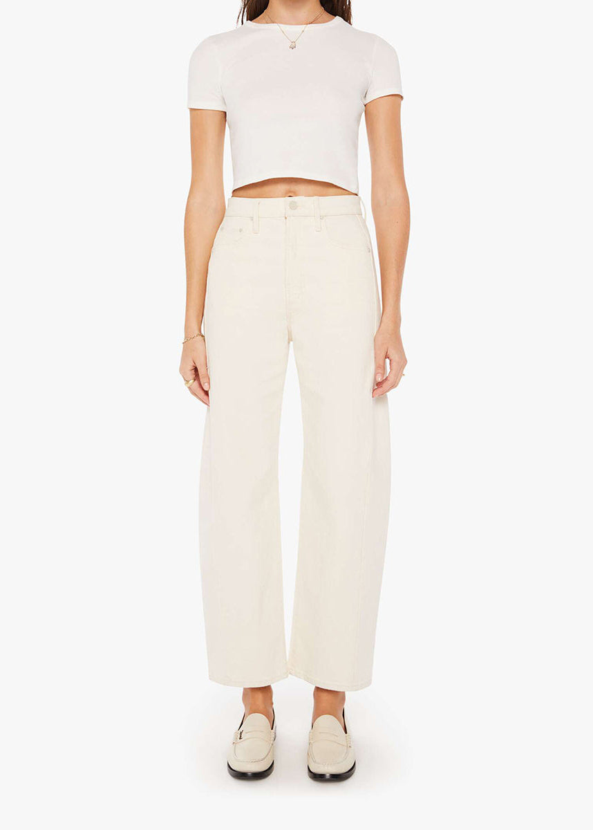 Person wearing a white crop top and cream-colored pants on a white background