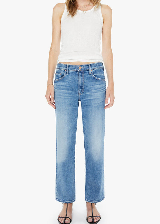 Woman wearing light blue jeans and a white sleeveless top on a white background