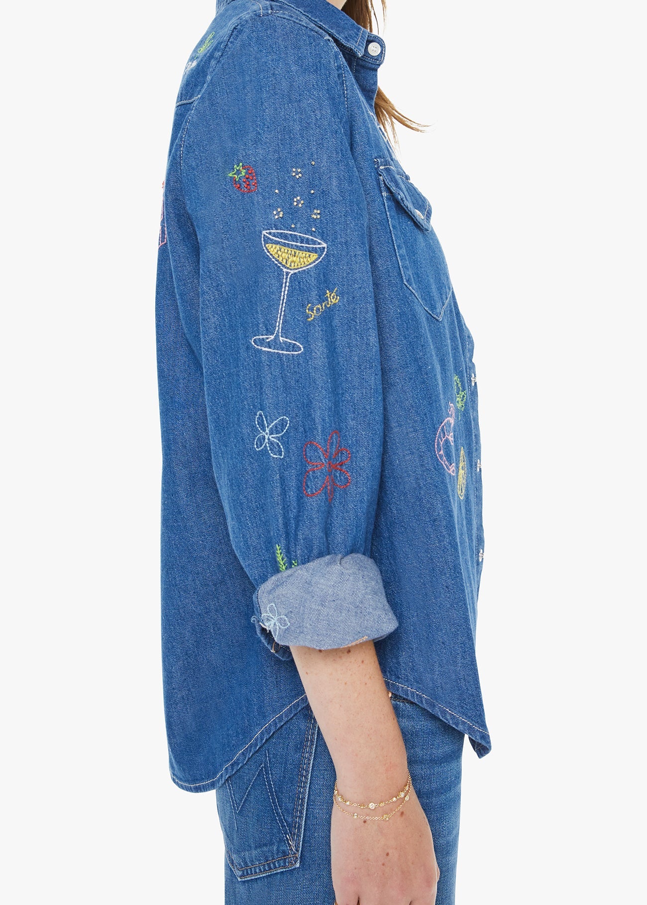 Blue denim shirt with colorful embroidery on a white background