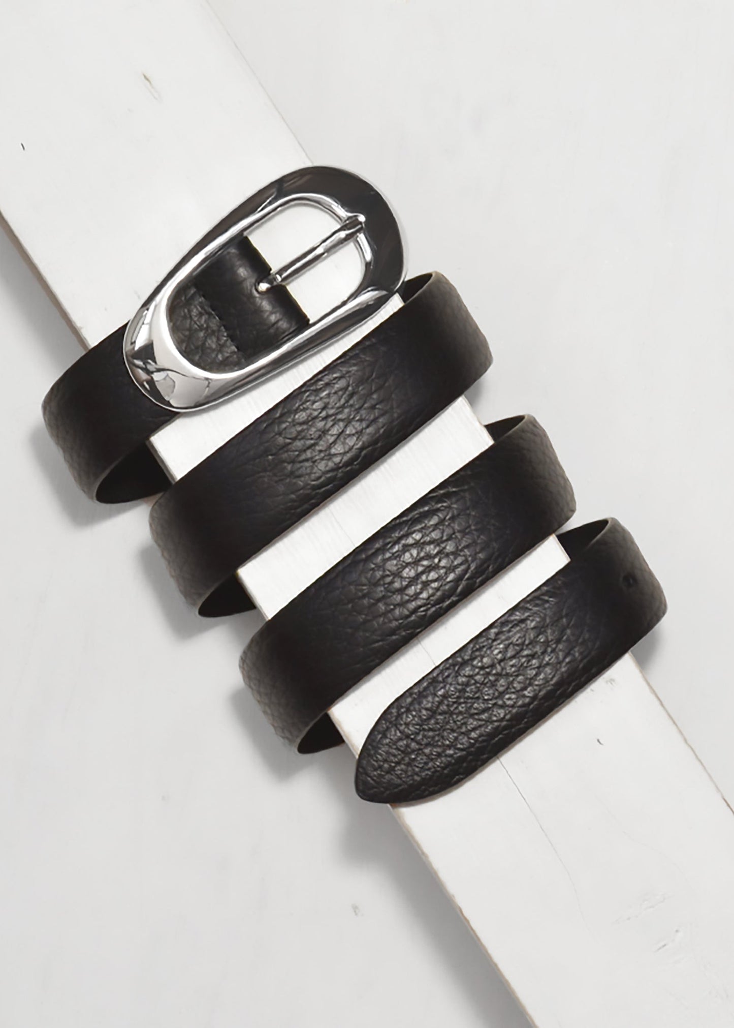 Black leather belt with a silver buckle on a white background