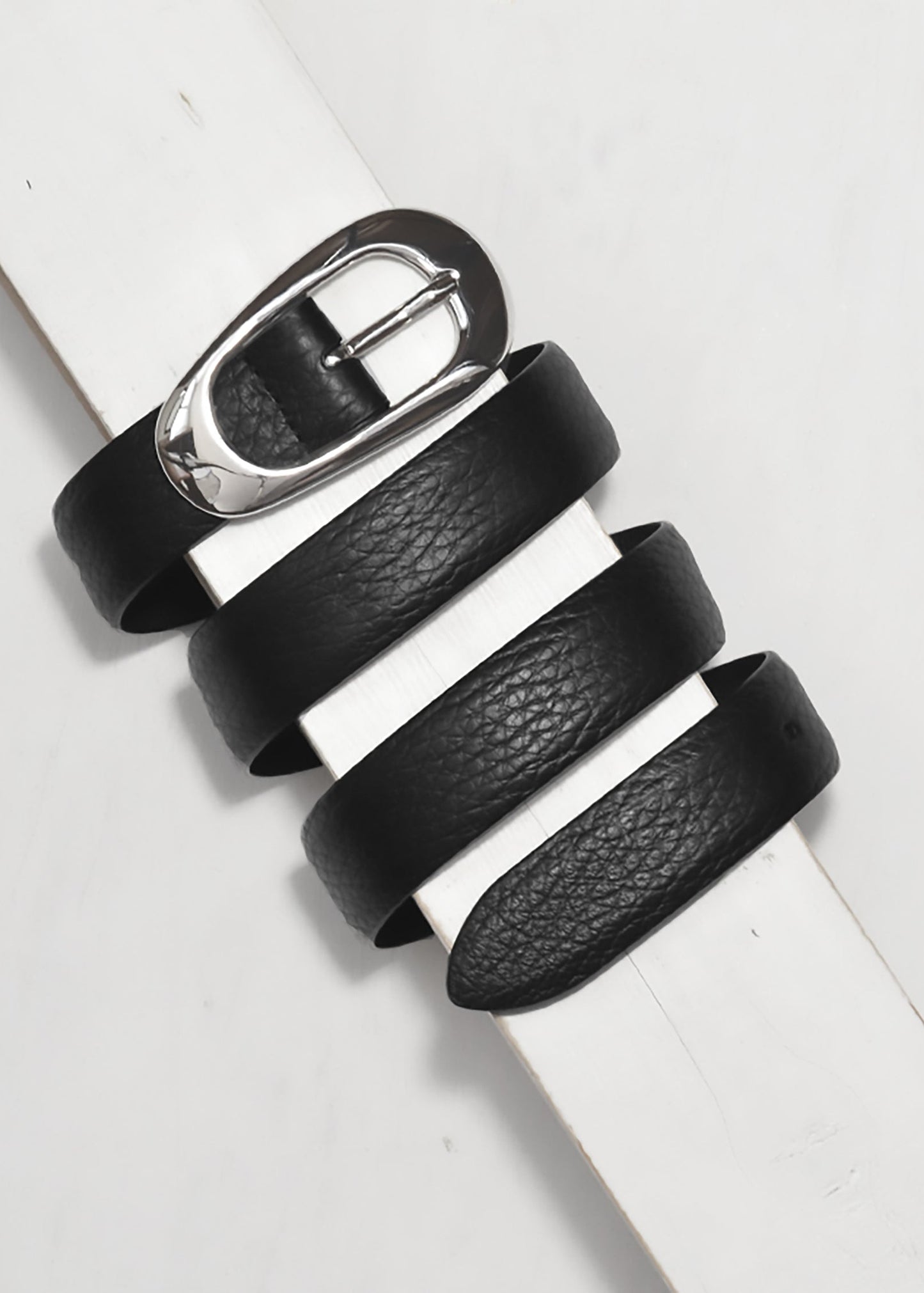 Black leather belt with silver buckle on a white background