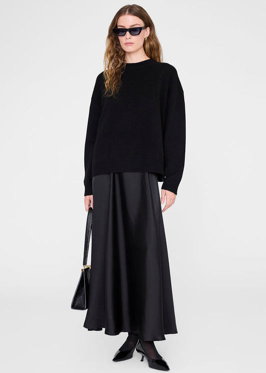 Woman wearing a black outfit with sunglasses on a white background