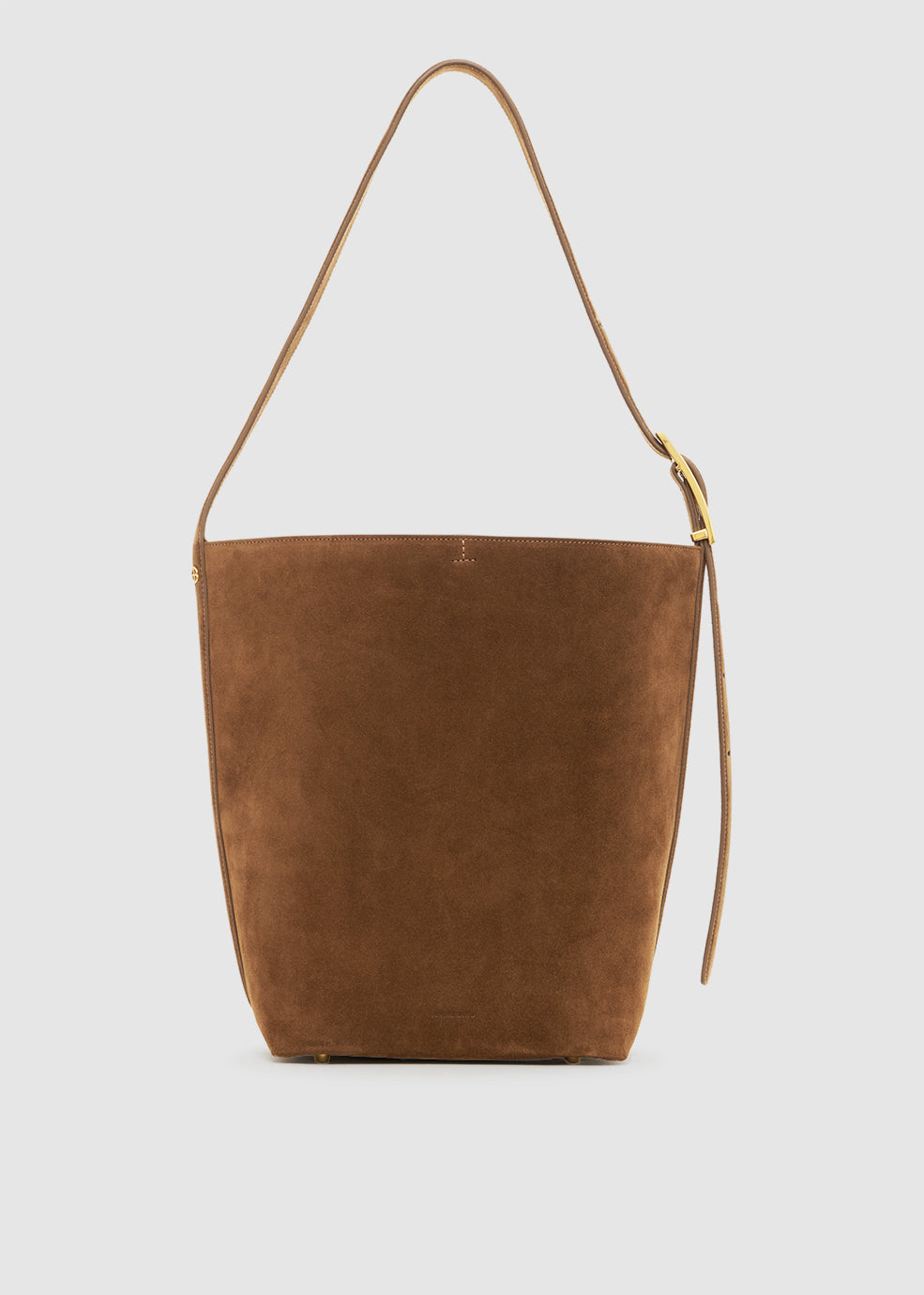 Brown suede handbag with a strap on a light gray background