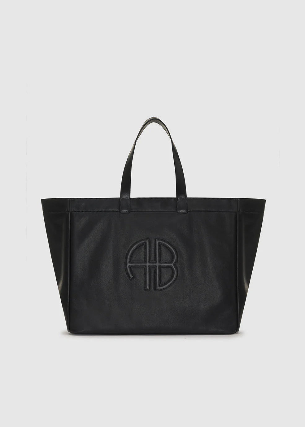 Black tote bag with a logo on a light gray background