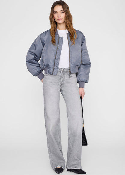 Woman wearing a gray jacket and jeans on a white background