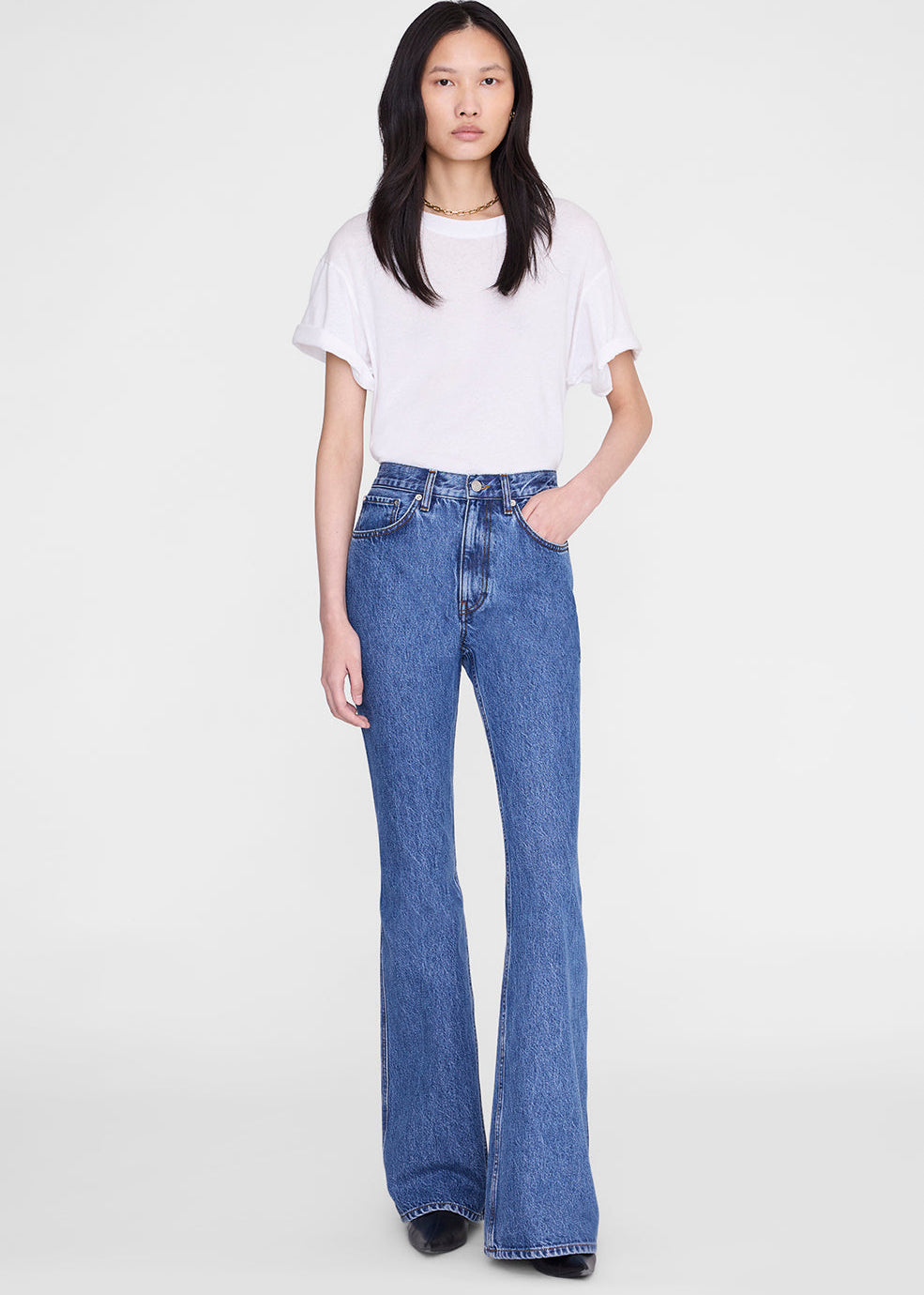 Person wearing a white t-shirt and blue jeans on a white background