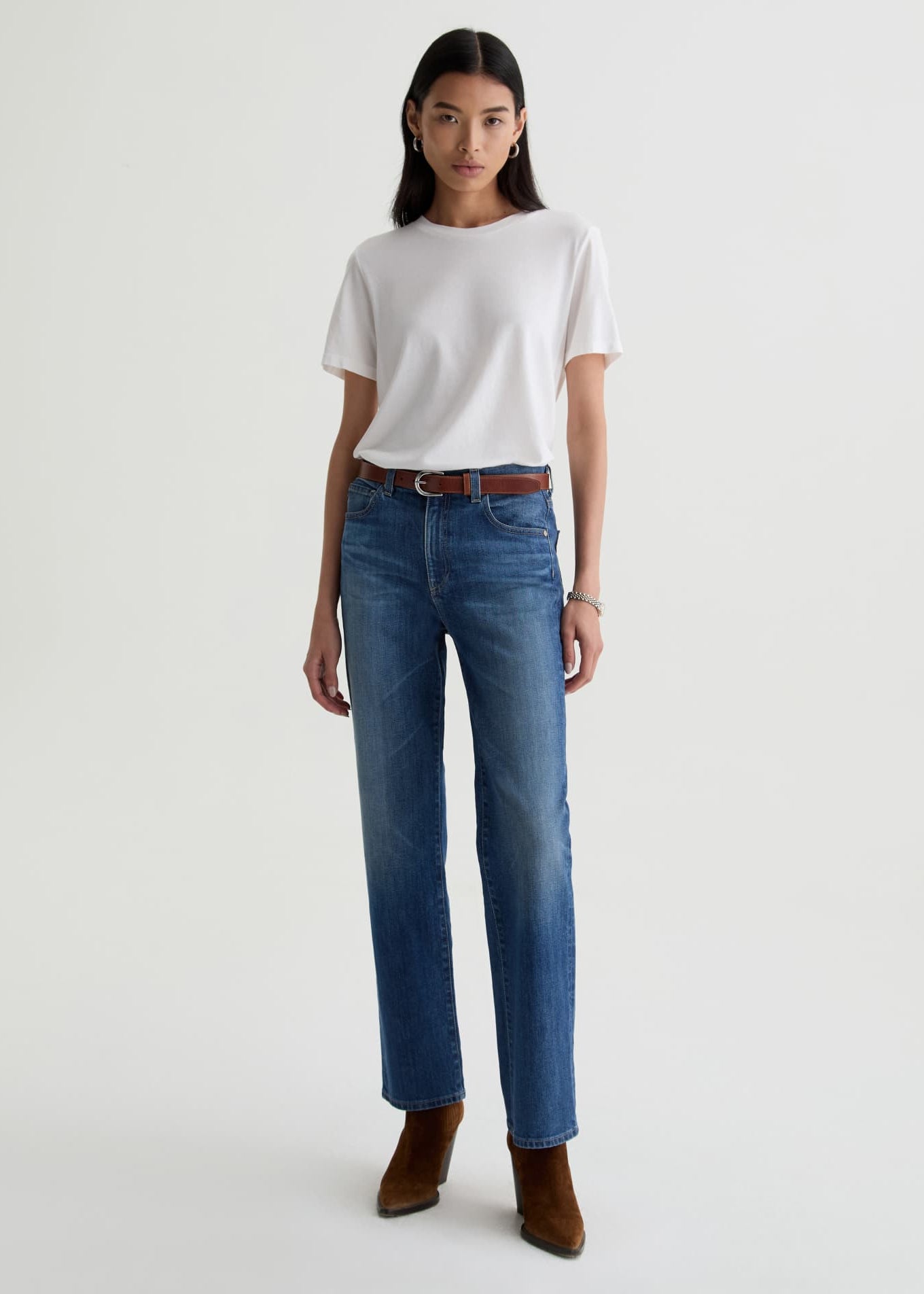 Person wearing a white t-shirt and blue jeans on a white background