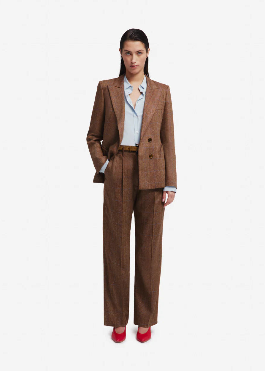 Woman wearing a brown suit with a white shirt on a white background