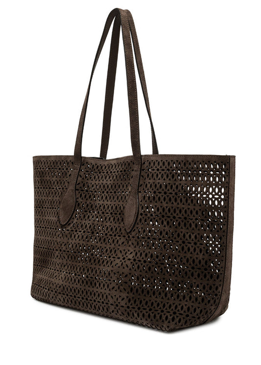 Brown woven tote bag with leather handles on a white background