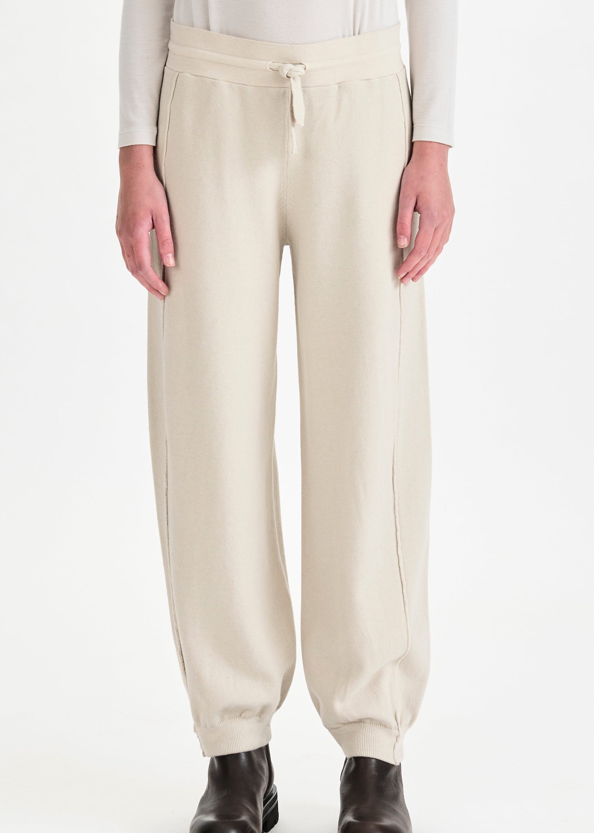 Beige pants worn by a person on a white background