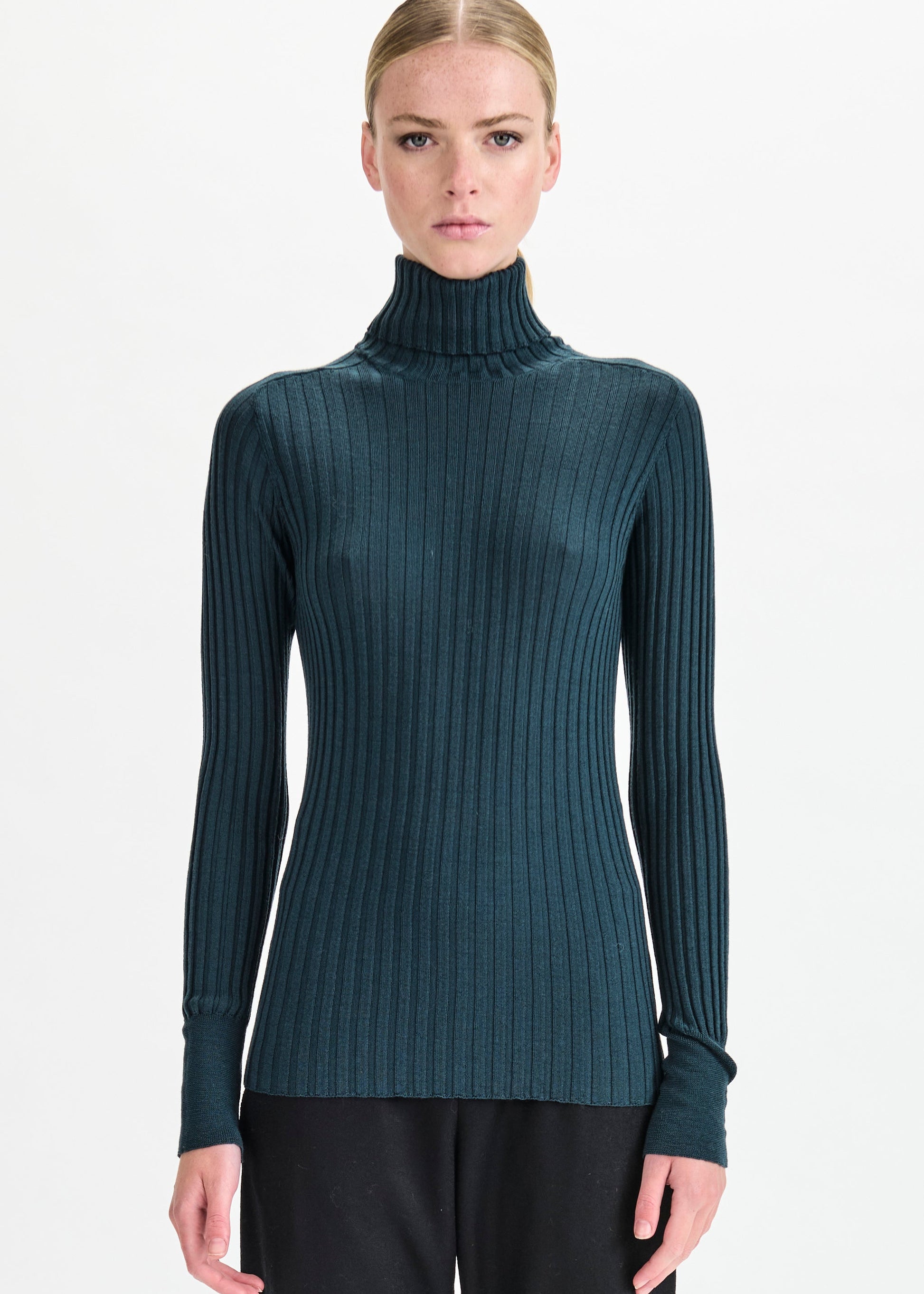 Woman wearing a ribbed turtleneck sweater on a white background