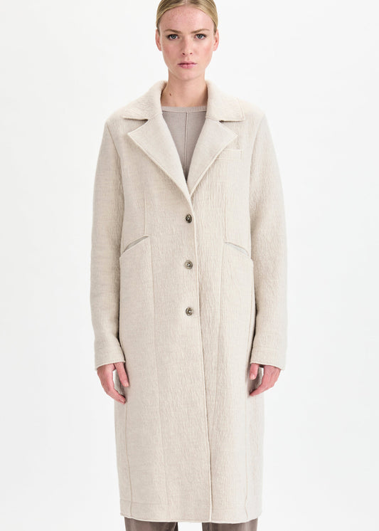 Woman wearing a beige coat on a white background