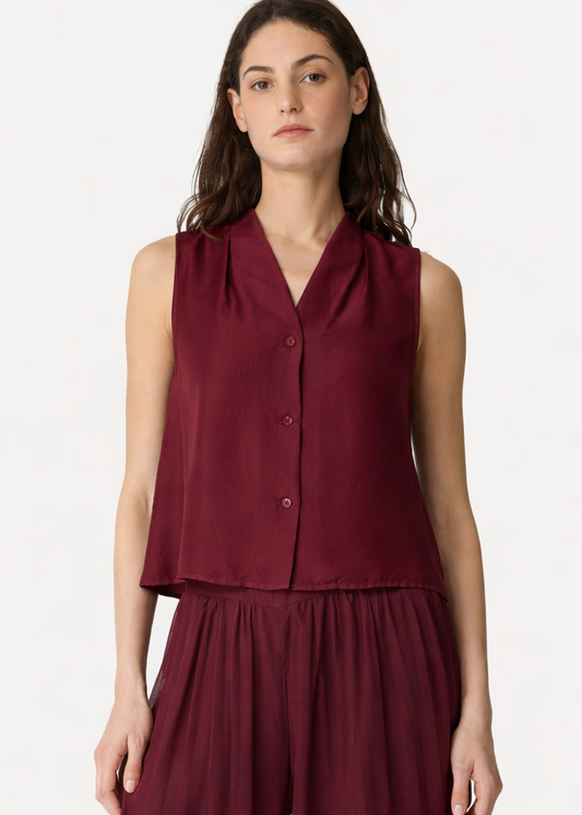 Woman wearing a burgundy sleeveless top and skirt set on a white background
