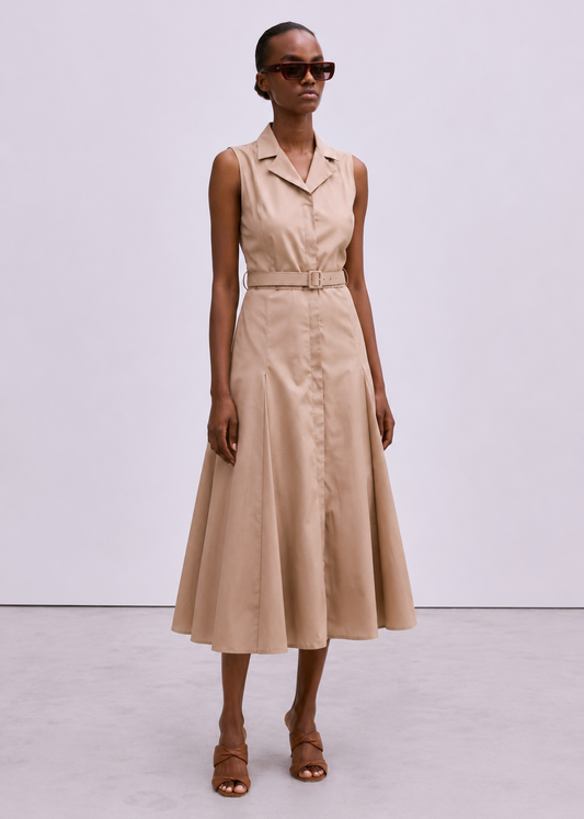 A model wearing a sleeveless beige midi dress with a collar, button front, and matching belt, styled with brown strappy sandals and dark sunglasses against a light gray studio background.
