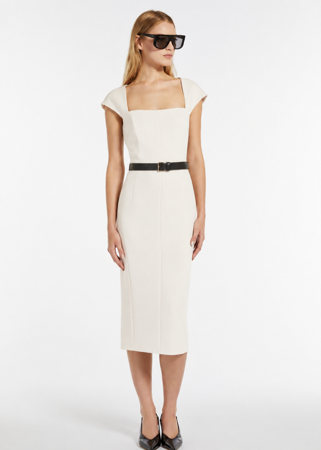 Woman wearing a white dress with a black belt on a white background