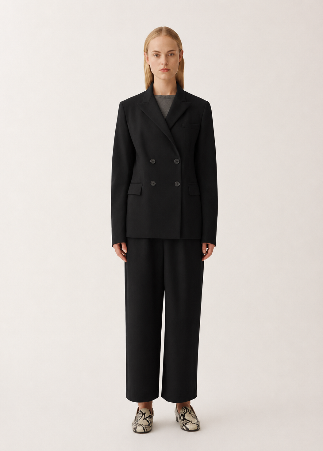 Person wearing a black suit on a white background