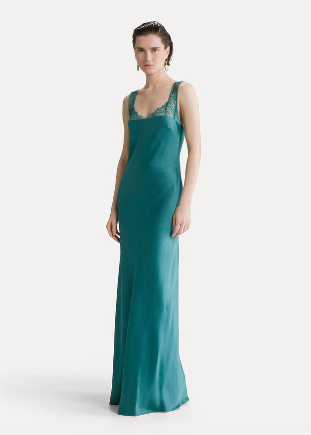 Woman wearing a teal evening gown with a white background