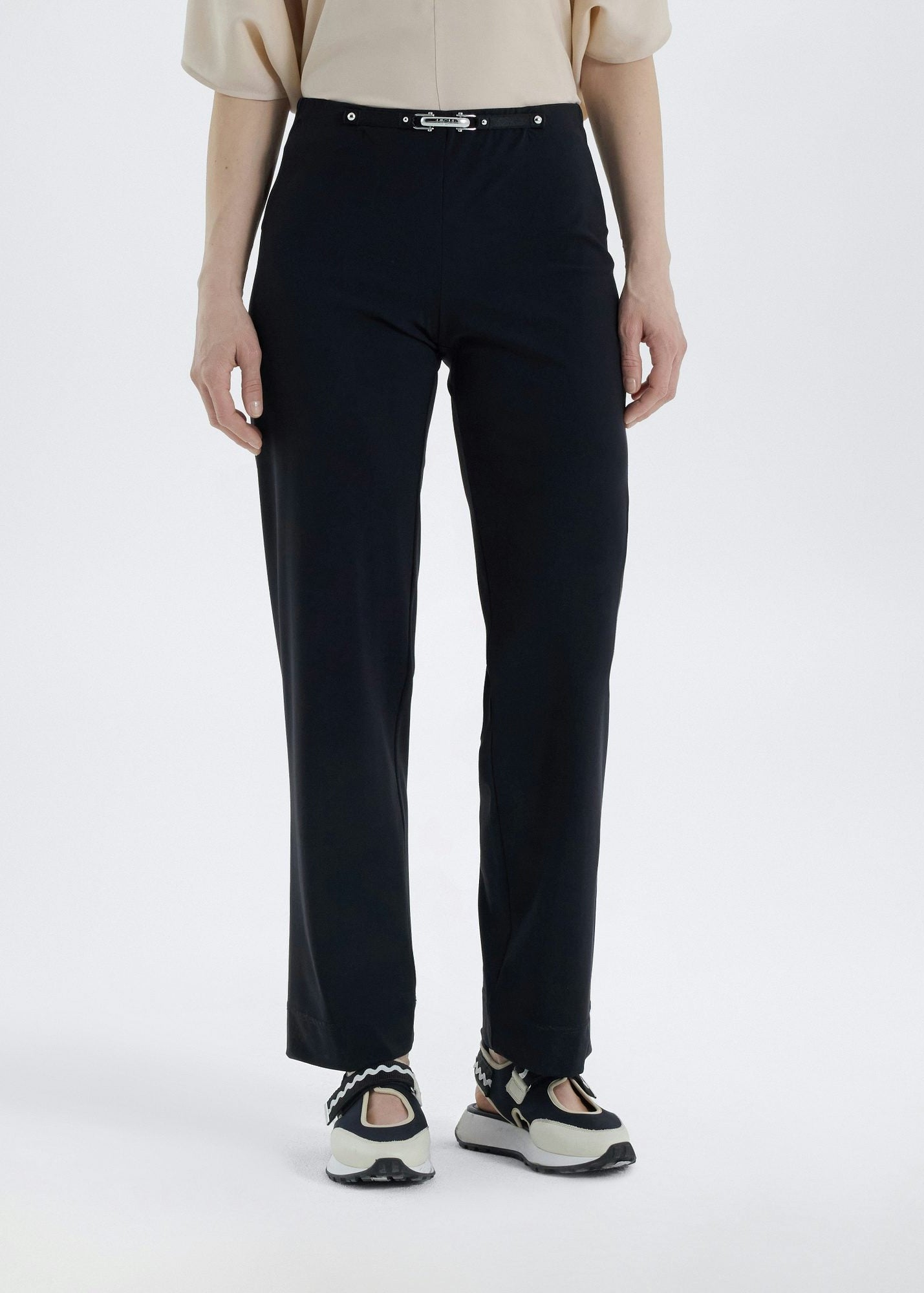 Person wearing black pants on a white background