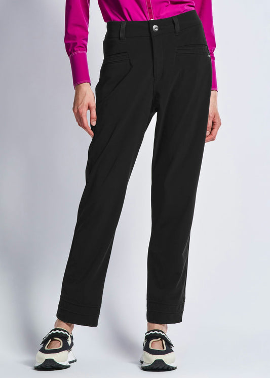 Person wearing black pants and a pink shirt on a white background