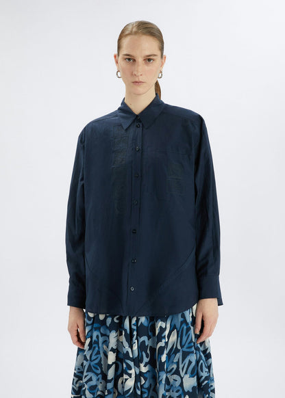 Person wearing a navy blue shirt with a white background