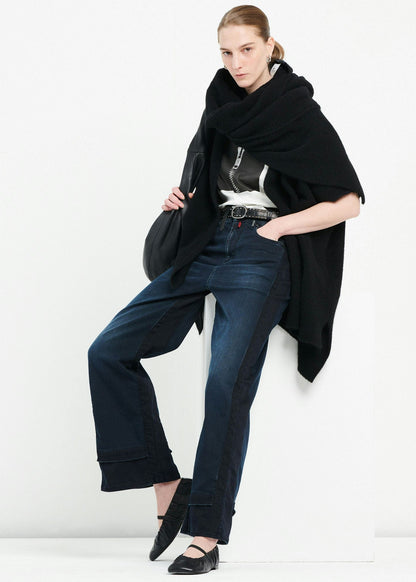 Woman wearing a black coat, blue jeans, and black shoes on a white background