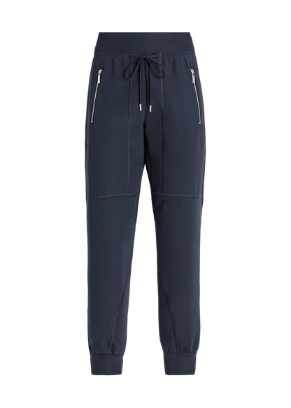 A pair of dark navy blue jogger-style pants with zippered side pockets, a drawstring waist, and elastic cuffs, shown against a plain white background.