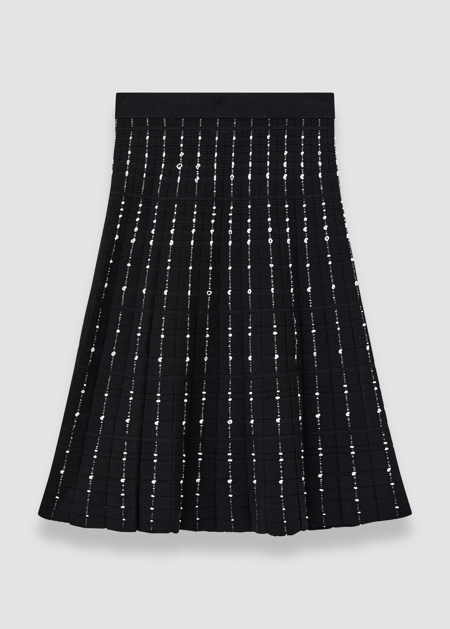 Black pleated skirt with silver embellishments on a light gray background
