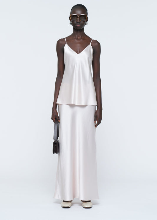 Woman wearing a white sleeveless top and pants on a white background