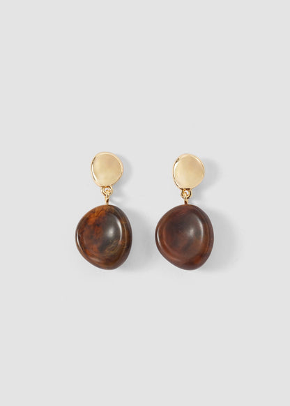 A pair of drop earrings featuring polished dark brown stone pendants and round gold-tone posts, displayed against a solid light gray background.