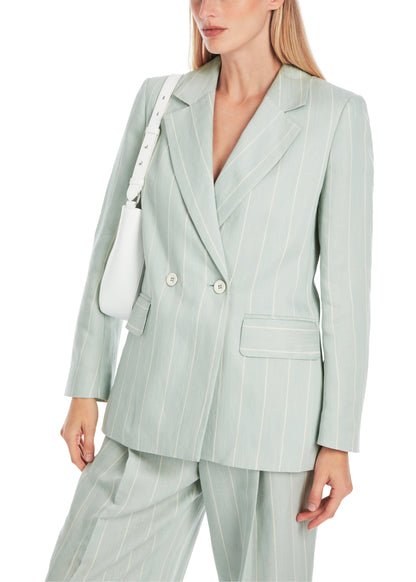 Woman wearing a light green pinstripe suit with a white bag on a white background