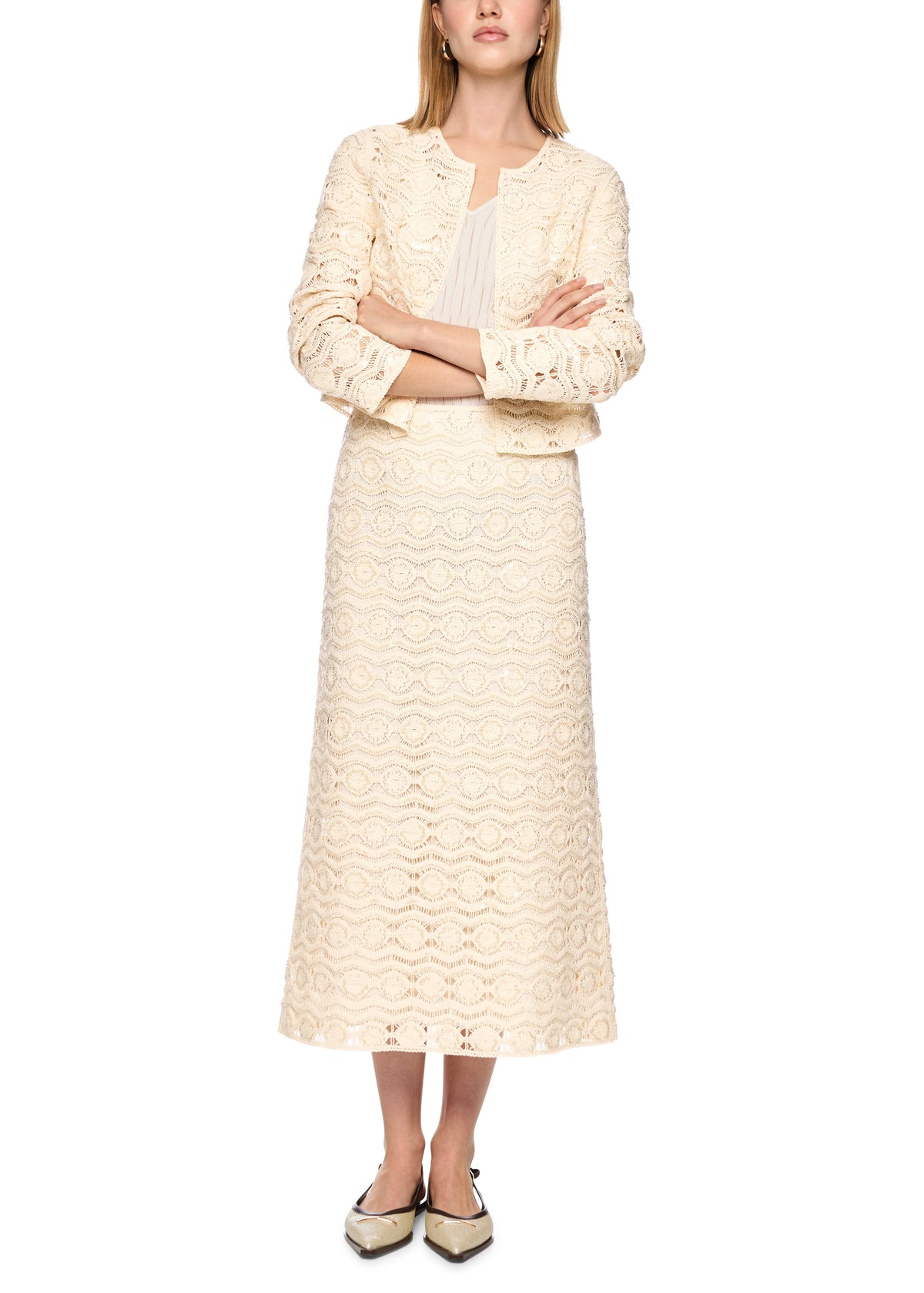 Woman wearing a cream-colored lace dress on a white background