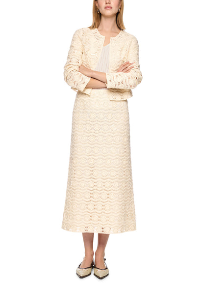 Woman wearing a cream-colored lace dress on a white background