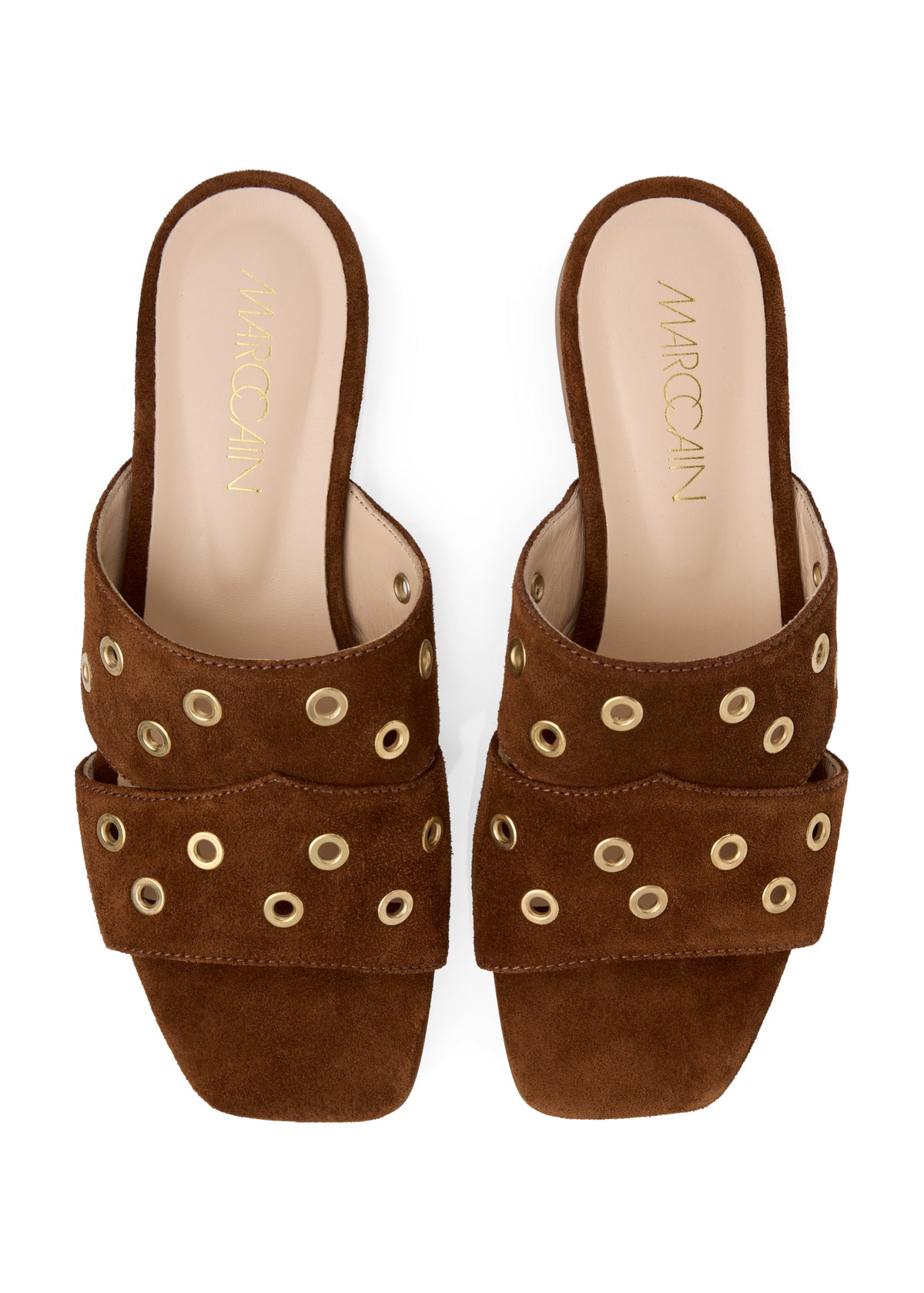 A pair of brown suede slide sandals with double straps adorned with gold-tone metal grommets, shown from a top-down view on a white background. The insole features the brand name 'MARCCAIN' in gold lettering.