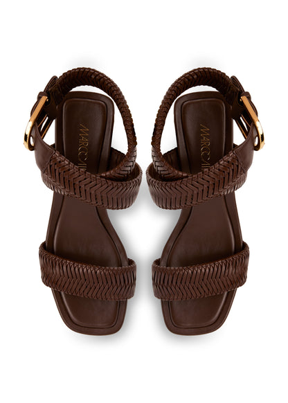 Pair of brown sandals with braided straps on a white background