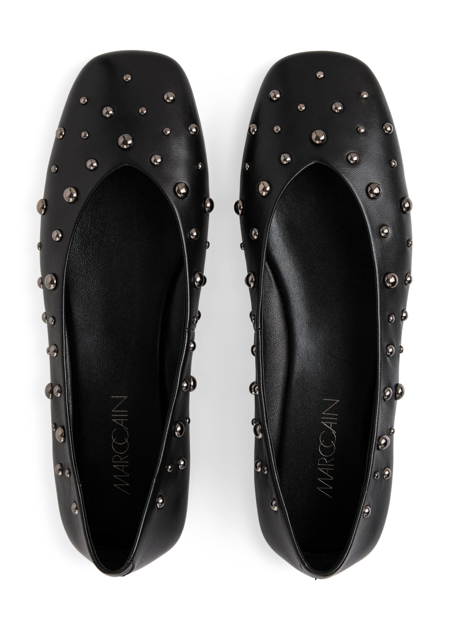 Black studded flats with 'Marcoclin' branding on a white background