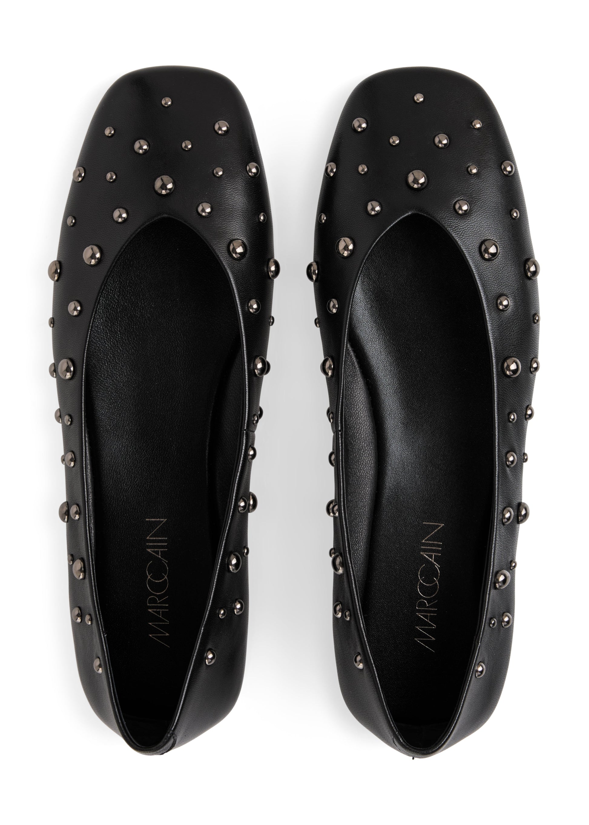 Black studded flats with 'Marcoclin' branding on a white background