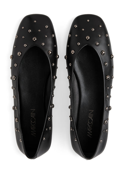 Black studded flats with 'Marcoclin' branding on a white background
