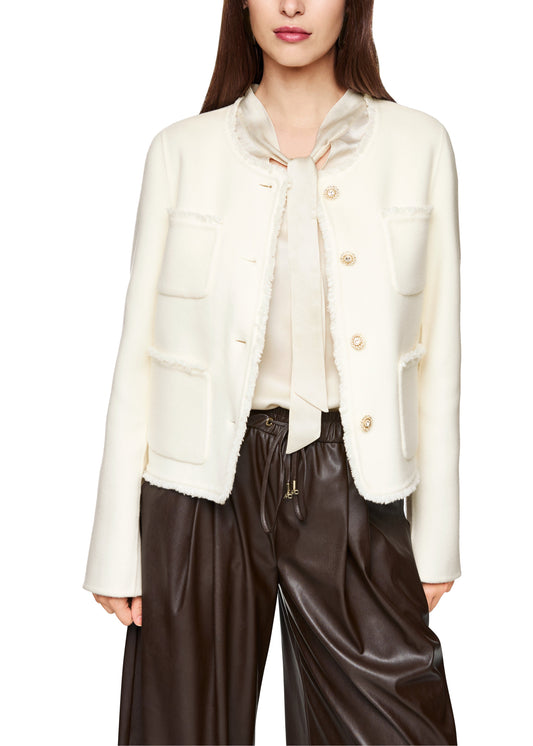 Woman wearing a white jacket and brown pants on a white background