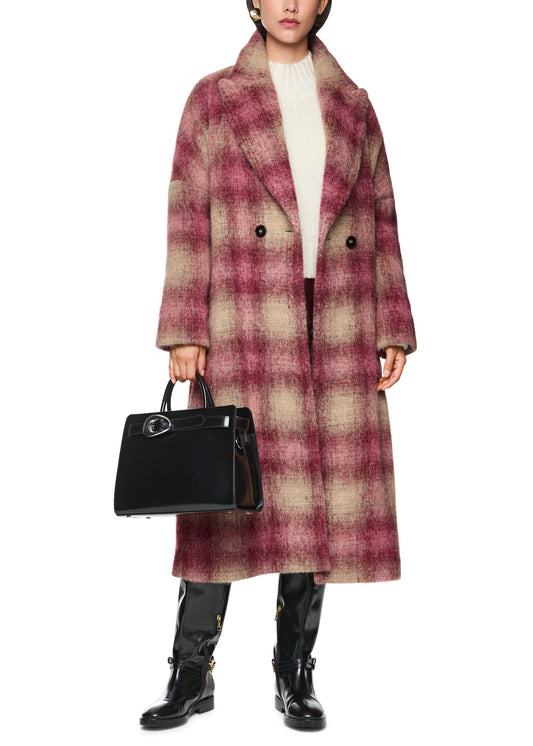 Person wearing a plaid coat holding a black handbag on a white background