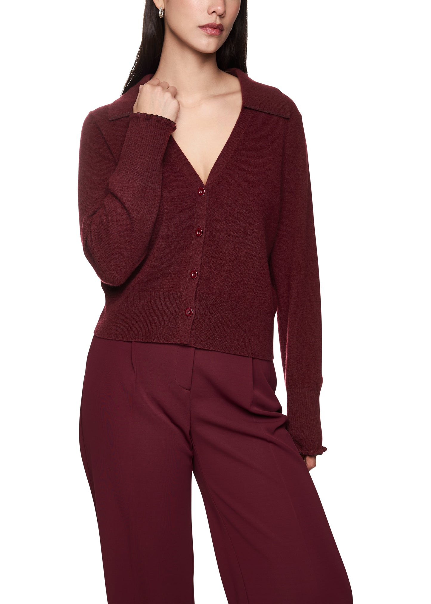 Woman wearing a burgundy cardigan and pants on a white background