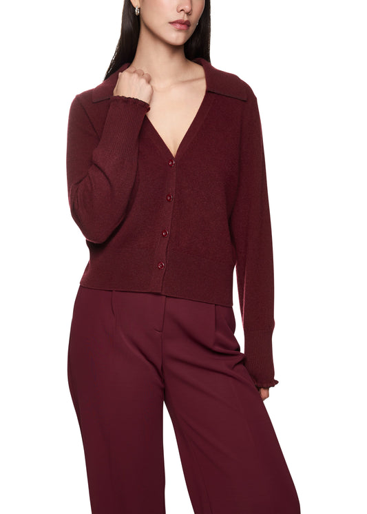 Woman wearing a burgundy cardigan and pants on a white background