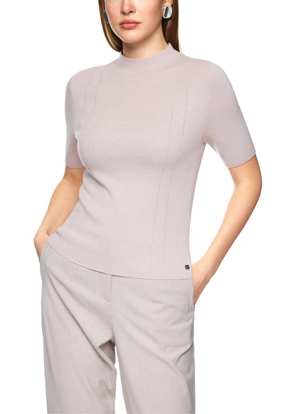 Woman wearing a light gray outfit with a top and pants on a white background