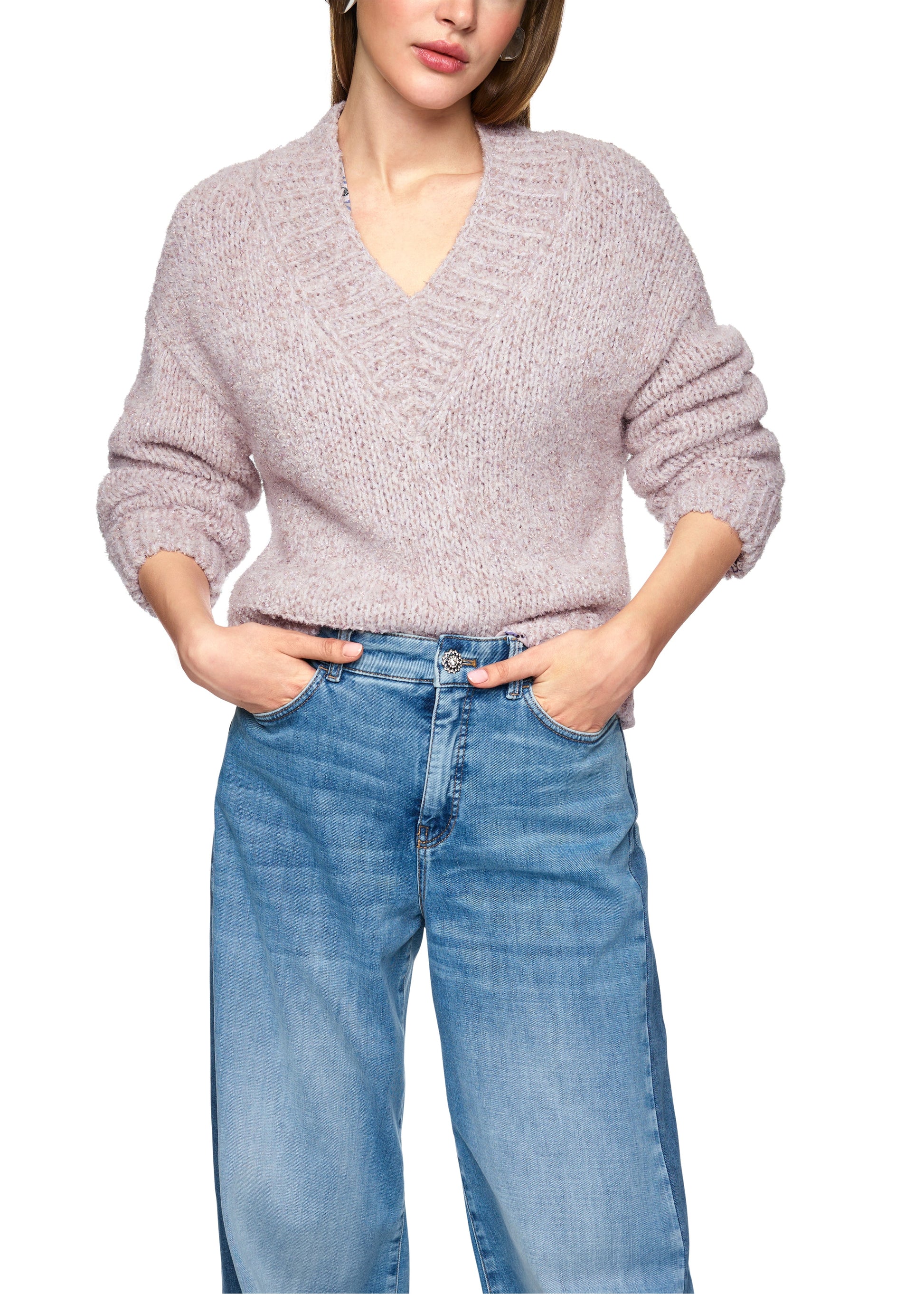 Person wearing a light gray sweater and blue jeans on a white background