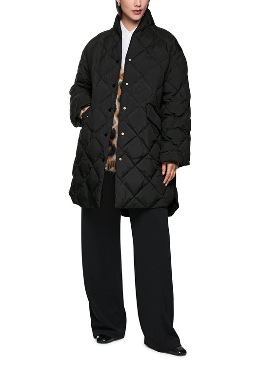 Person wearing a black quilted jacket on a white background